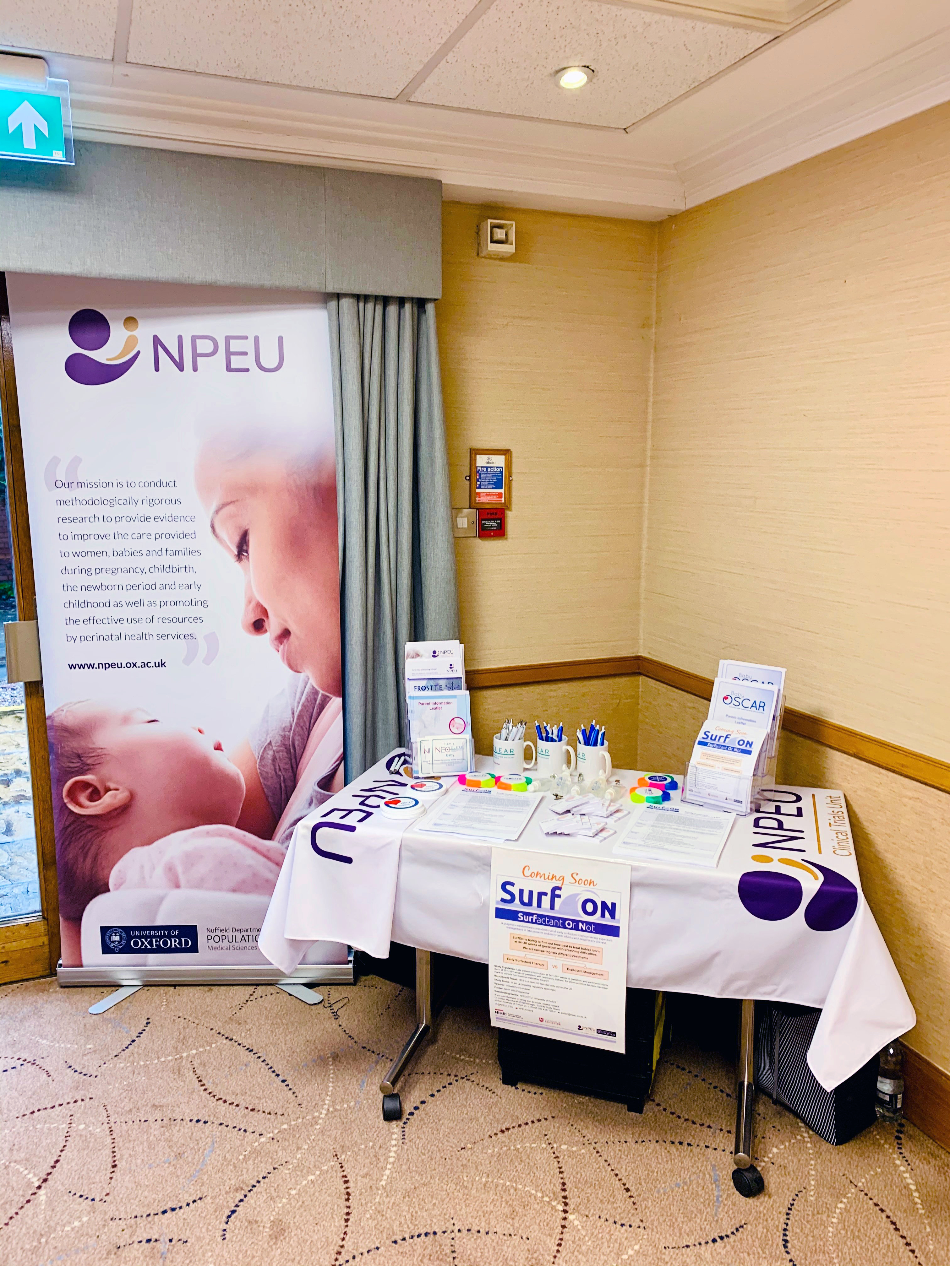 The SurfON stall - a table with paraphernalia and an NPEU banner